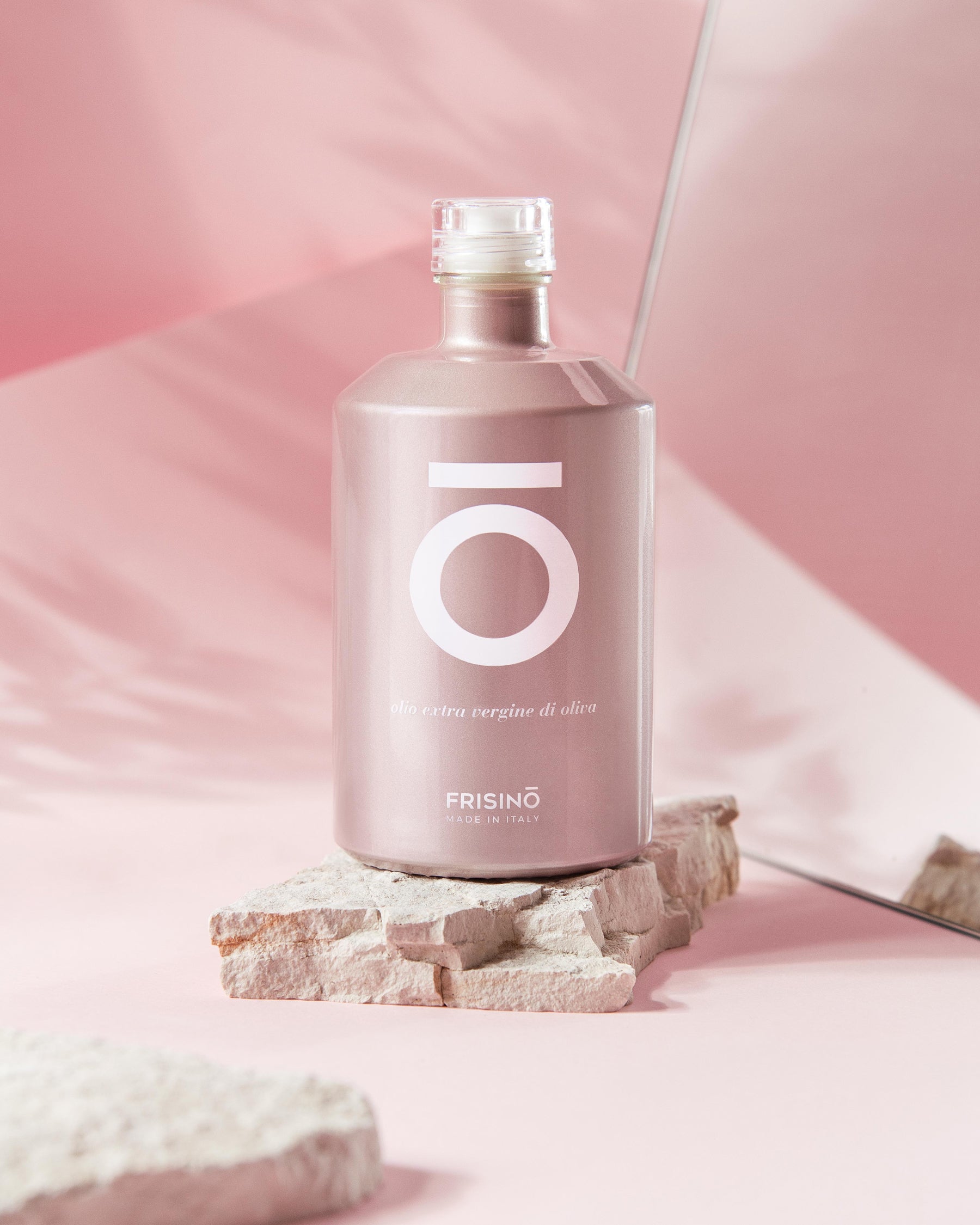 Frisino Limited Rosé extra virgin olive oil pink bottle on light stone, pink backdrop with mirror