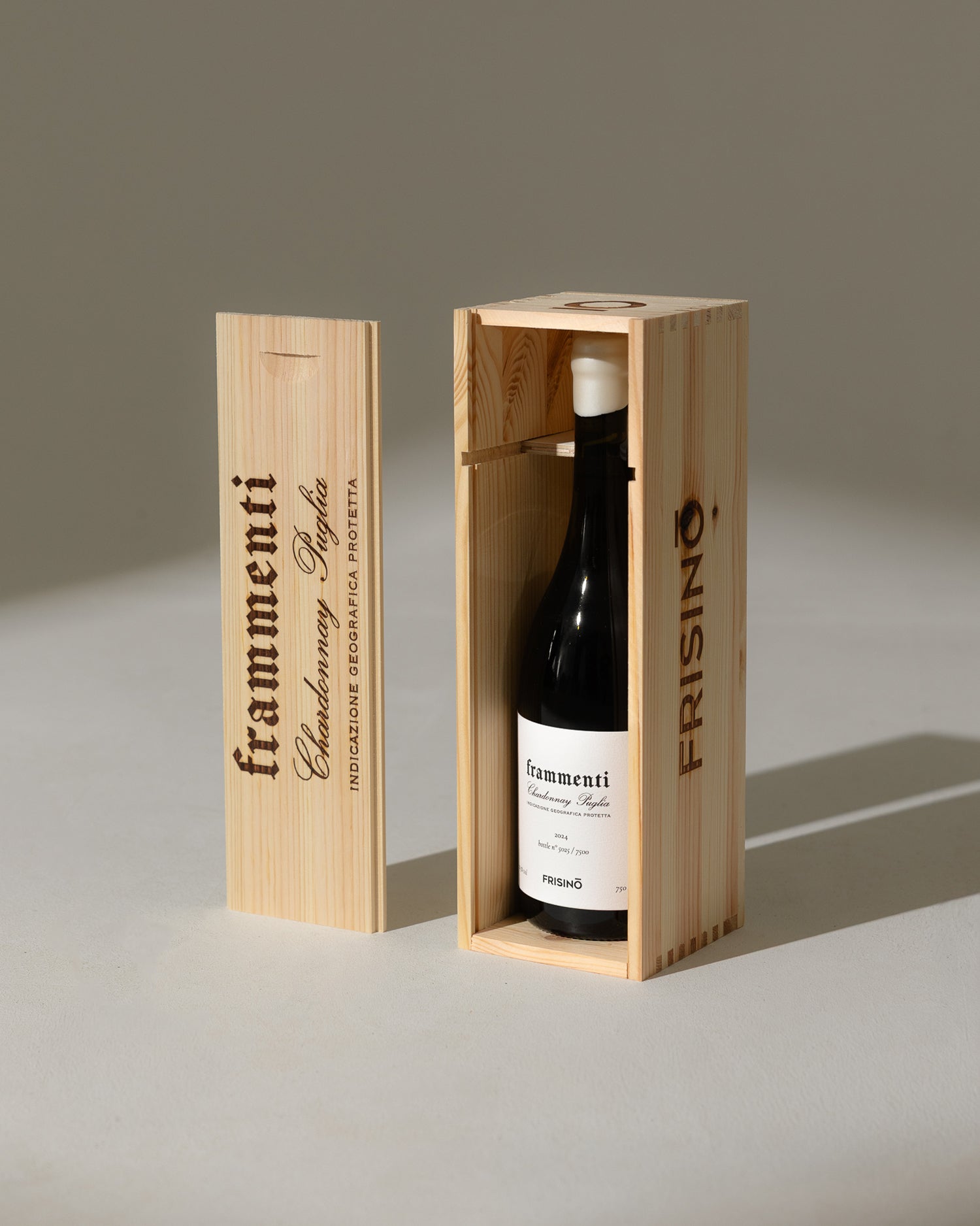 Frisino Frammenti Chardonnay Puglia IGP 2024 bottle in engraved wooden gift box with sliding lid beside